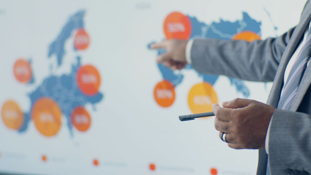 Consultant presenting global market growth data on a large screen