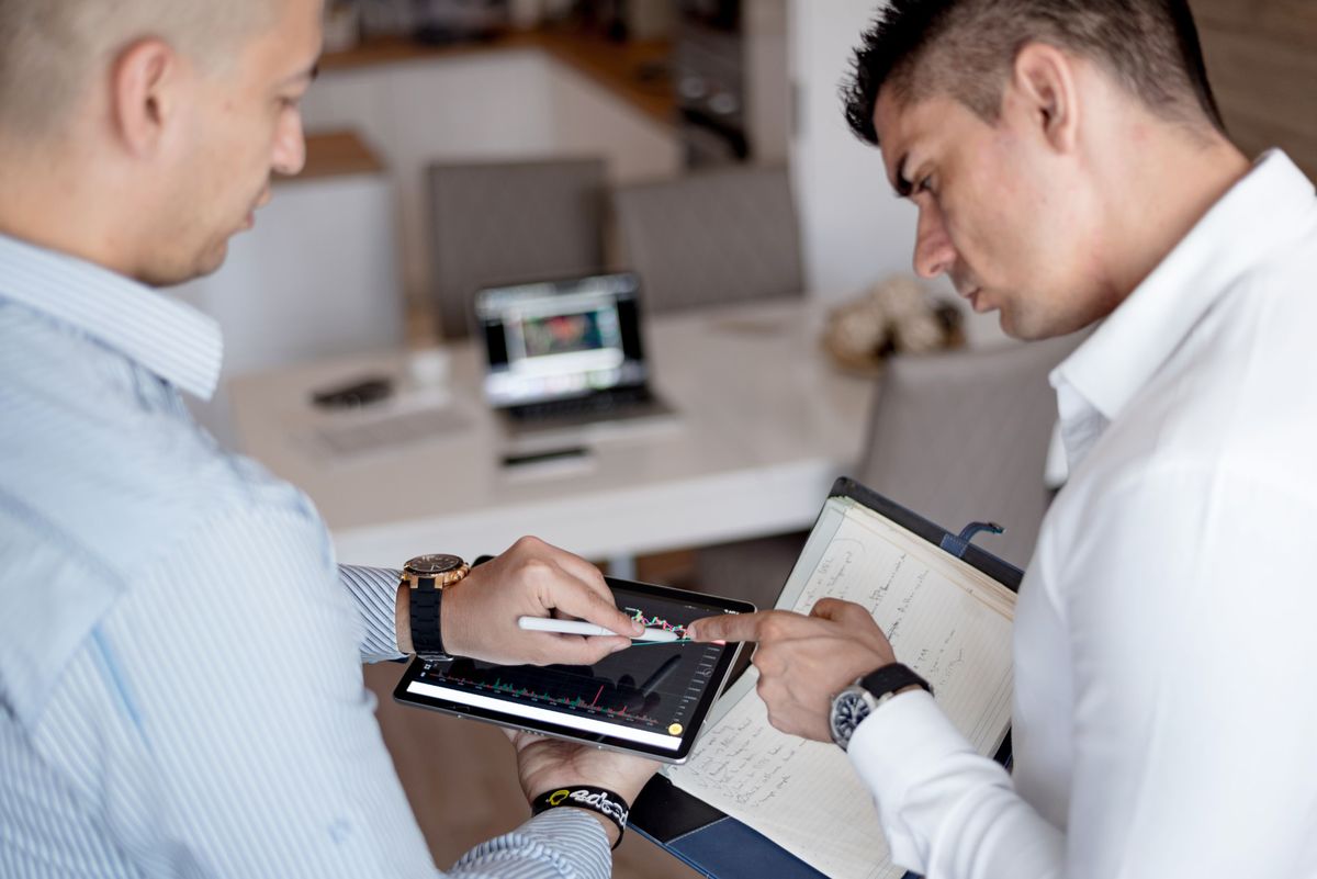 Two consultants reviewing performance charts on a tablet