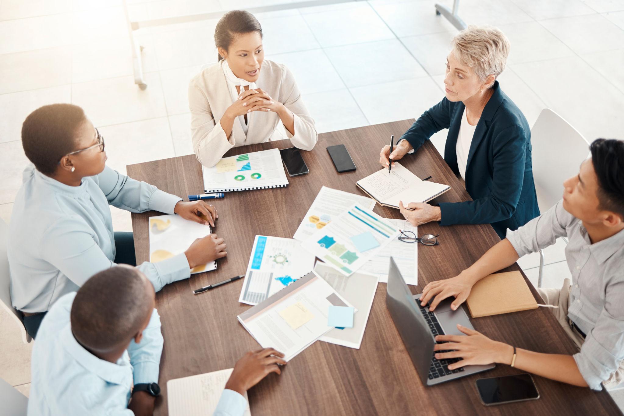 A consulting team reviewing strategy reports and pipeline data