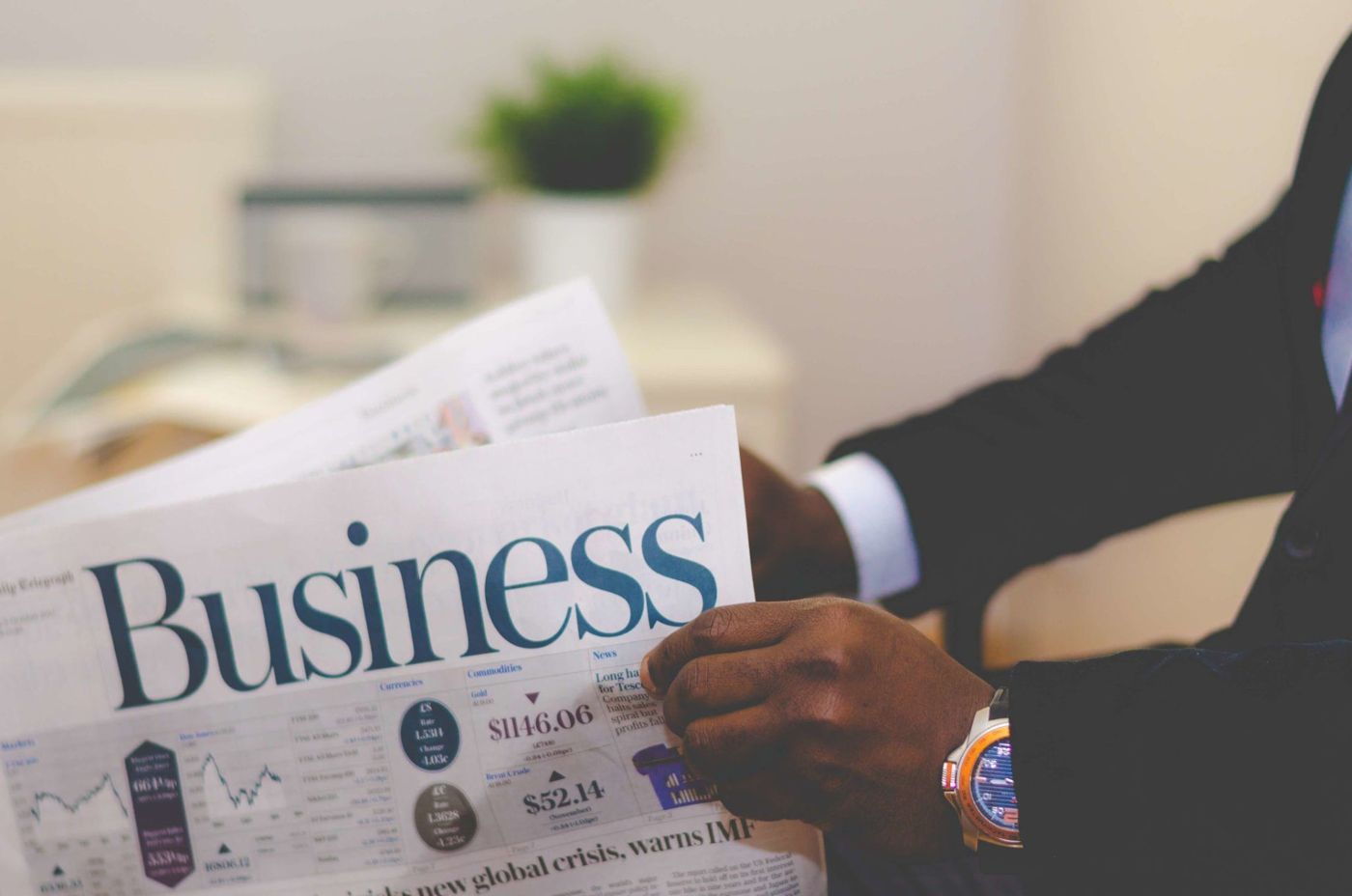 Professional reading the business section of a newspaper
