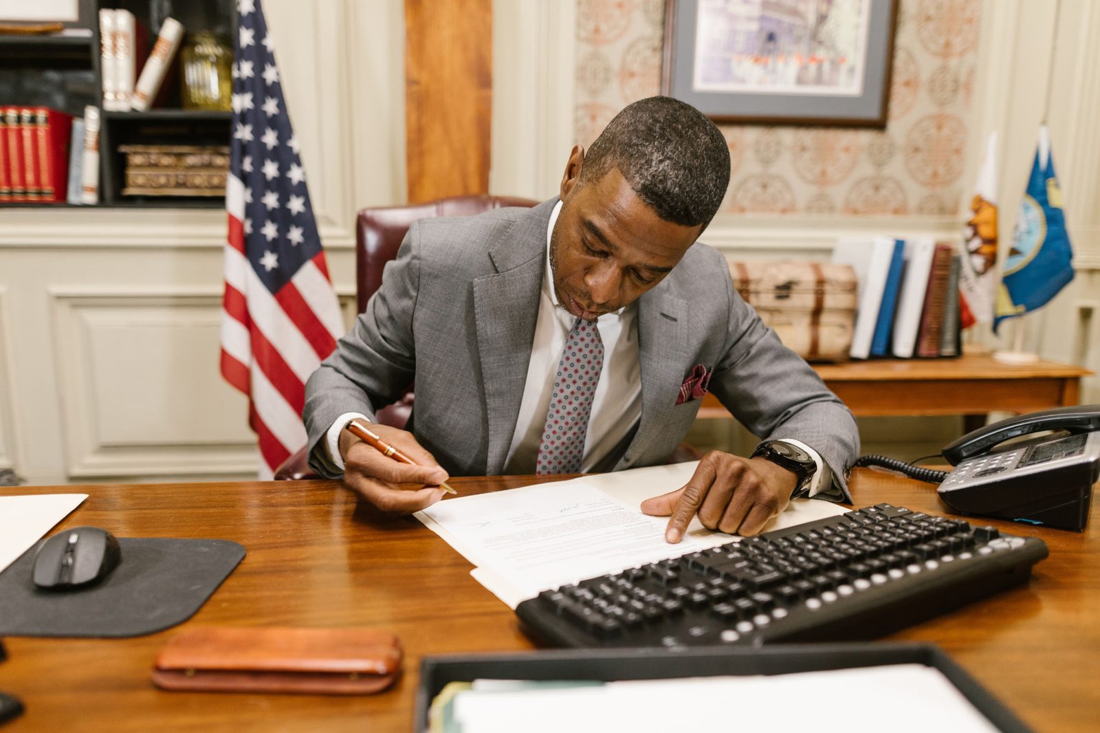 Executive reviewing and signing a consulting agreement at a desk