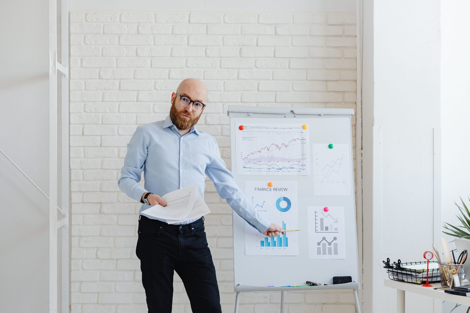 Sales leader presenting performance charts on a flip chart in a bright office