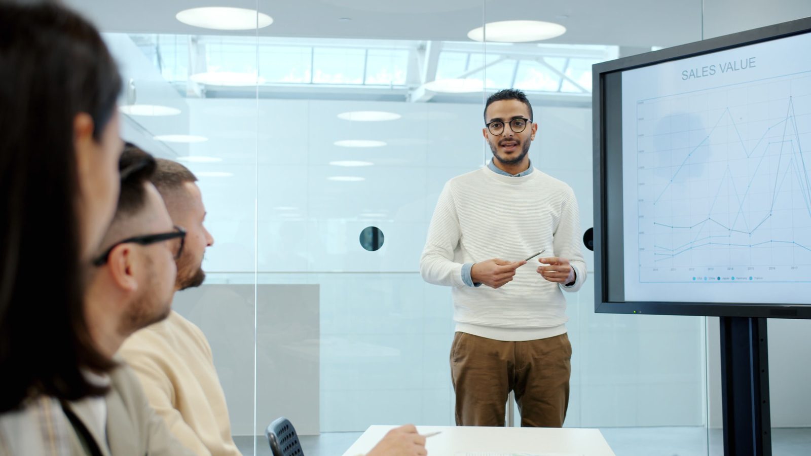 Sales leader walking a leadership team through a sales value chart in a conference room